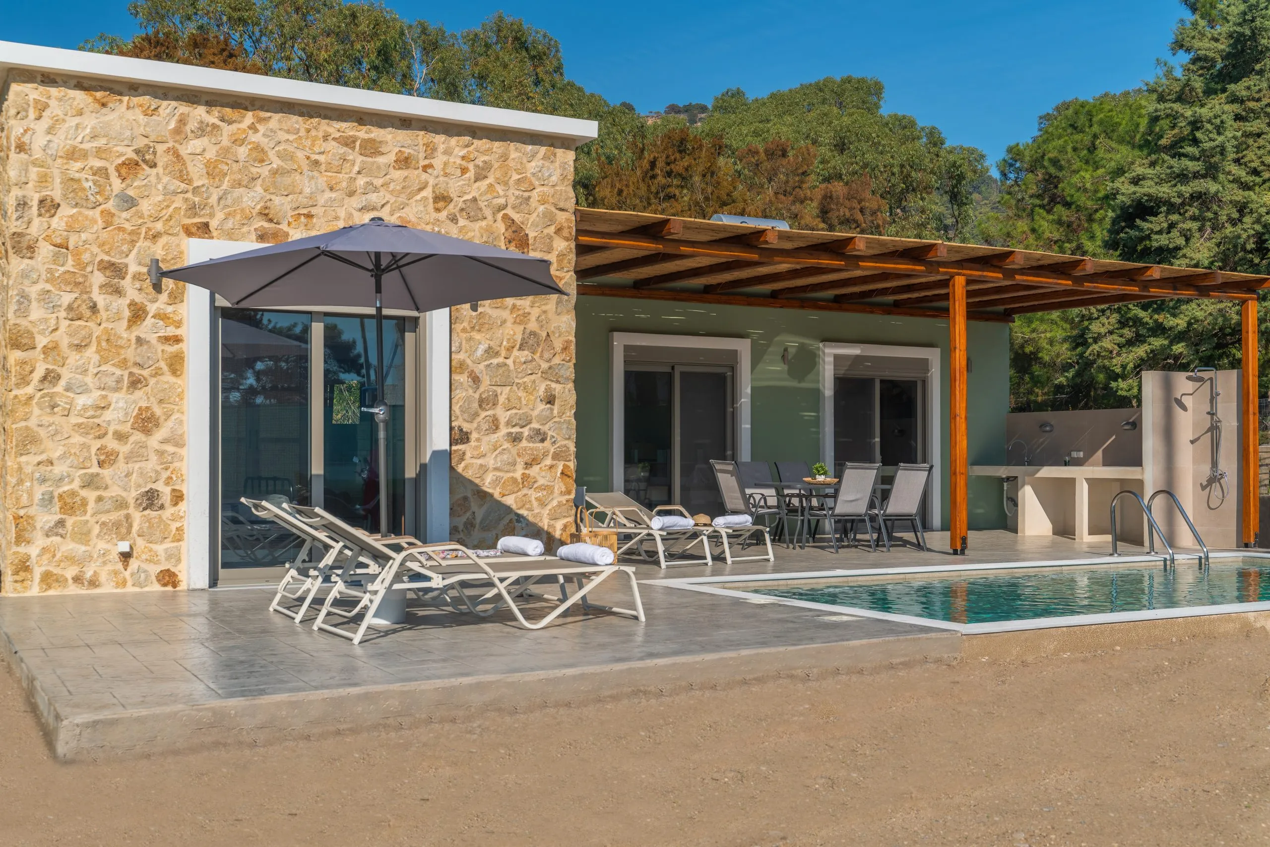The villa exterior with pool and loungers