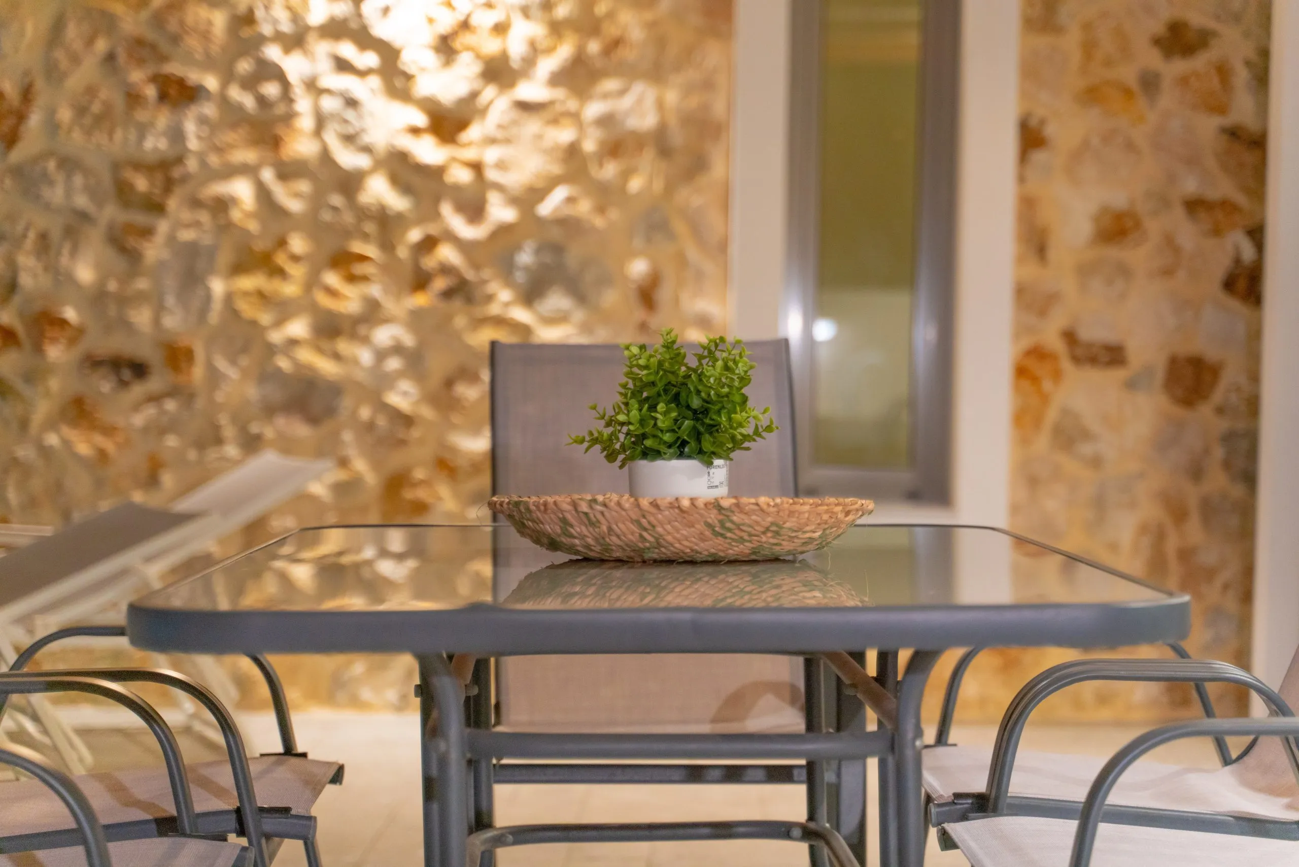 Terrace table with plant against the stone wall