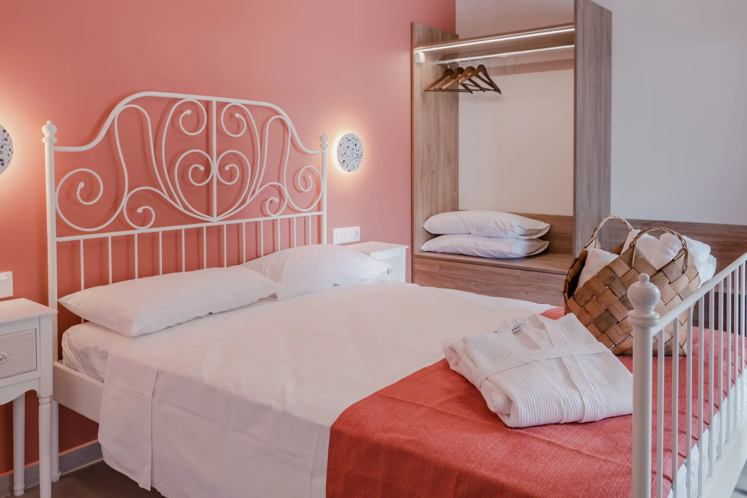Bedroom with white iron bed and coral wall