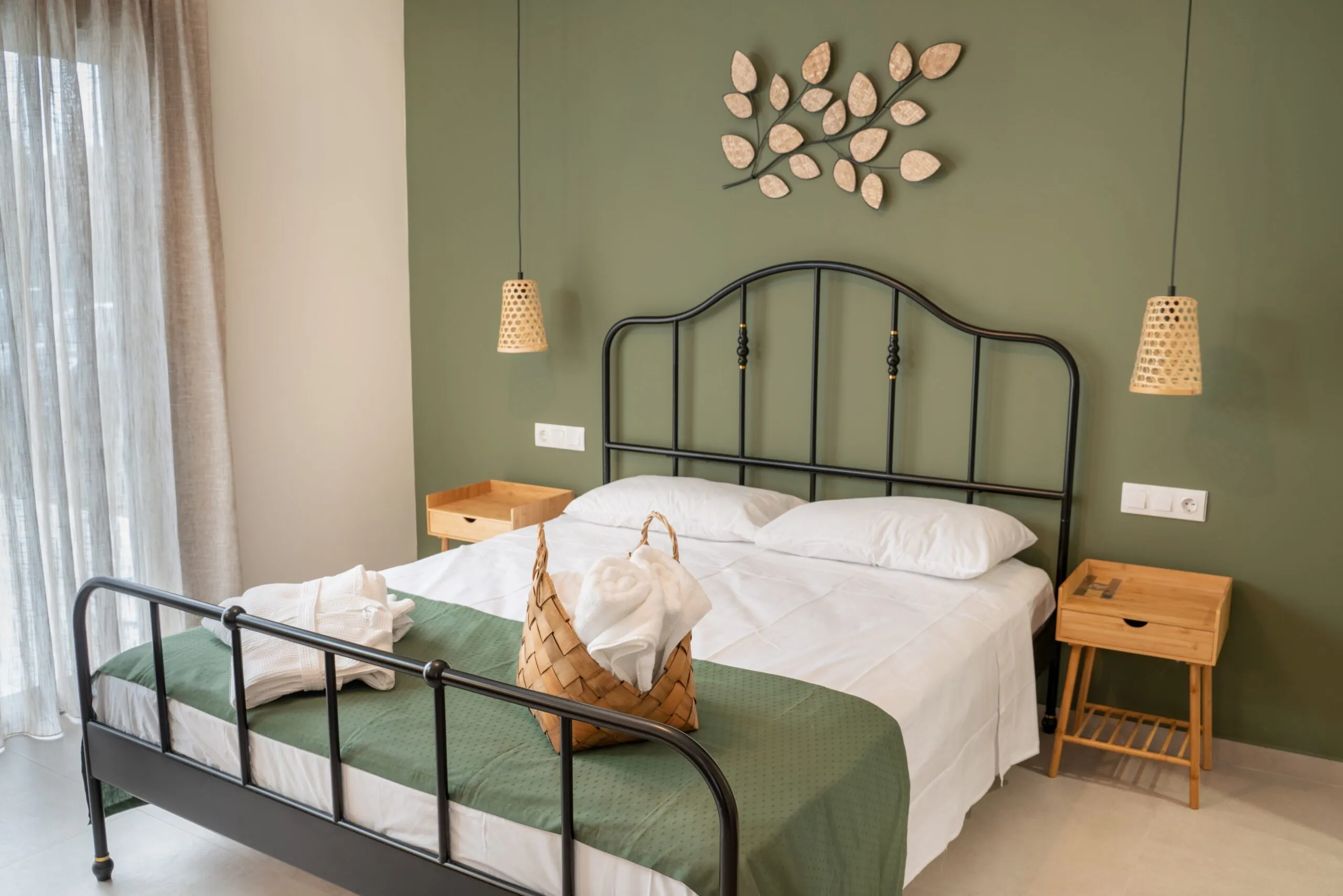 Bedroom with black iron double bed and green wall
