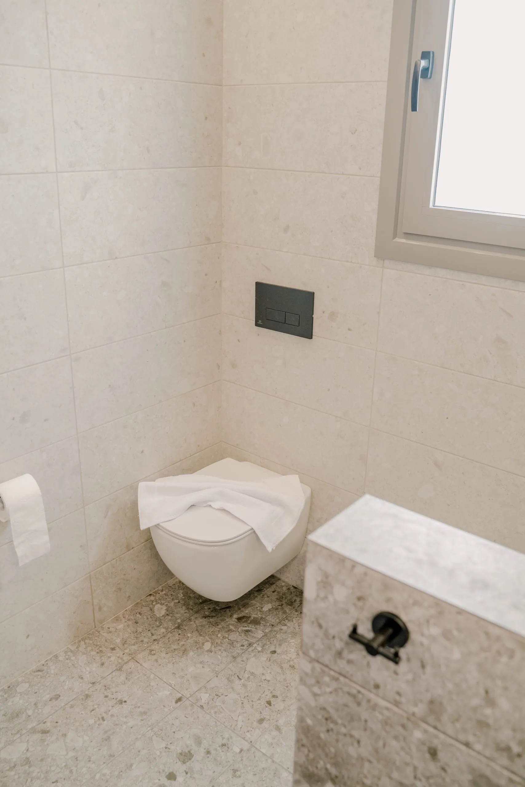 Bathroom with wall-hung toilet and towels